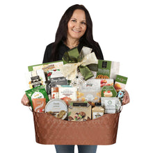 Gift basket with brown woven container of assorted cookies and candy held by woman