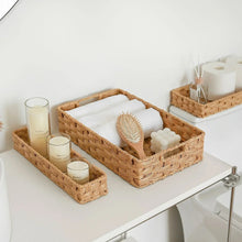 Set of three rattan-style storage bins with open tops and woven walls, tan
