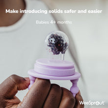 Silicone baby feeder teether with purple handle holding a clear teething nipple cover