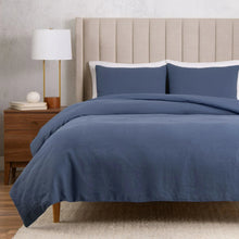 Blue cotton-linen duvet cover set with two pillow shams on a bed