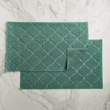 Two green geometric bath mats with textured quatrefoil pattern, set of 2