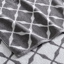 Close-up of gray jacquard bath towel with white lattice diamond design, textured weave