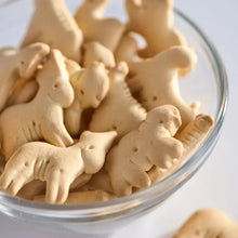 Animal crackers close-up in clear container, tan animal-shaped biscuits
