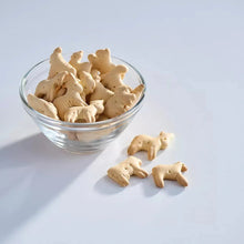 Animal crackers in a glass bowl with a few loose pieces nearby
