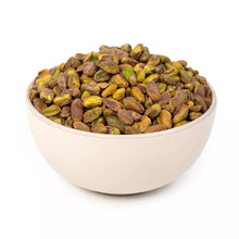 Salted roasted pistachio kernels in a white bowl, whole nuts