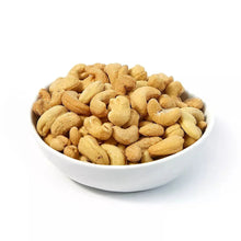 Salted roasted cashews in a white bowl, light golden cashew pieces