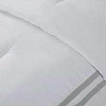 White comforter fabric with subtle stitching and gray stripe border