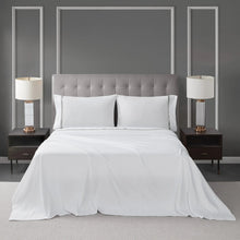 White 4-piece sheet set on bed with pillowcases and draped top sheet
