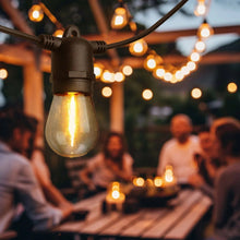 Solar string light set with warm vintage bulbs glowing on an outdoor string