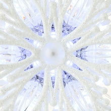 White LED snowflake tree topper close-up of glowing inner lights and central hub