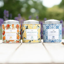 Three metal tea tins with colorful labels: Mango & Bergamot, English Breakfast, Earl Grey