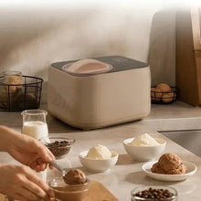 Taupe compact automatic ice cream maker with bowls of ice cream on kitchen counter