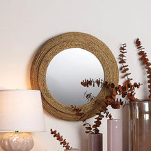 Round seagrass wall mirror with woven tan ring frame and circular glass center