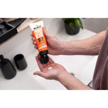 Beard soft conditioner tube held in hands with cap facing outward