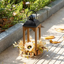 Wooden lantern with black handle, clear glass insert, decorated with fall flower cluster