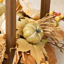 Pale yellow gourd ornament and dried leaves in fall lantern decor