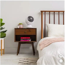 White globe fan on a small stand, angled view with gray front grille