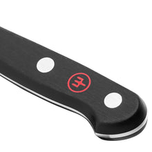 Knife handle end with white dot rivets and red emblem on black grip
