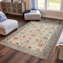 Washable indoor area rug laid flat, beige background with teal and rust motif border