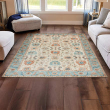 Washable indoor area rug with light beige base and teal-blue medallion pattern border