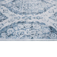 Washable indoor area rug close-up, light-blue medallion motifs and distressed texture