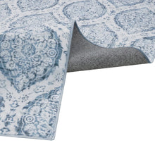 Blue and white indoor area rug corner with gray backing and stitched edge