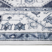 Blue and white patterned rug with motifs and decorative border along the edge