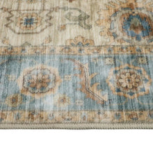 Washable indoor area rug texture close-up with blue, beige, and muted tan motifs