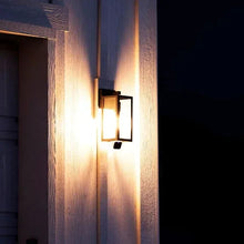 Outdoor wall bulb cam pair emitting warm light with frosted bulbs and camera lenses