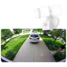 White wired security floodlight cameras mounted under an eave above a driveway