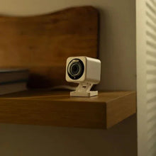 White indoor/outdoor security camera on a shelf with a swiveling lens
