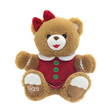 Brown teddy bear plush in red dress with green buttons and white trim, red bow