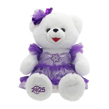 White teddy bear plush in purple snowflake dress with tutu and bow, '2025' badge