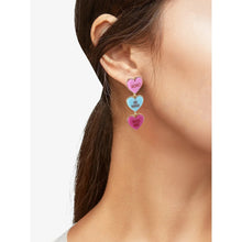 Candy heart drop earrings on ear, pink XOXO and blue BE MINE with magenta KISS ME heart.
