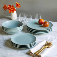 Light green dinnerware set with stacked plates, bowls, and clear drinking cups