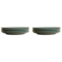 Light green dinner plates stacked in two groups, showing clean edges