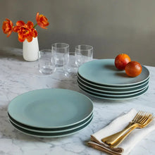 Light green dinner plate set with round plates stacked in two piles