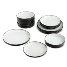 Black ceramic dinnerware pieces with white interiors: plates and small bowls