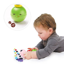 Baby playing with pink cow plush rattle on green light-up base