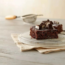 Dark chocolate dessert squares with white peppermint pieces on a plate