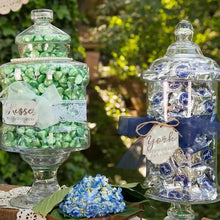 Bulk candy jars filled with dark chocolate peppermint patties outdoors with flowers