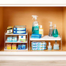 Metal cabinet shelf organizer with wire shelves holding spray bottles, sponge and cleaning tools