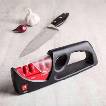 Black pull-through sharpener with red slots and curved finger grip