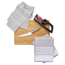 Pull-through sharpener on cutting board with chef knife and kitchen towels