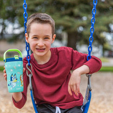 Child holding a Bluey character kids tumbler with orange lid on a swing