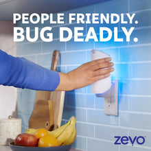 Zevo plug-in flying insect trap device on wall outlet beside fruit and kitchen items