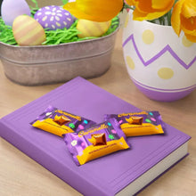 Purple Caramello mini chocolate packs on book with Easter eggs