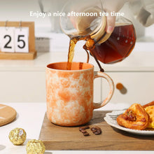 Orange speckled ceramic mug with side handle, filled with tea being poured
