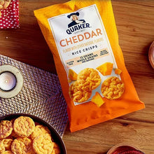 Cheddar rice crisps bag on a wooden table with cheese crackers nearby