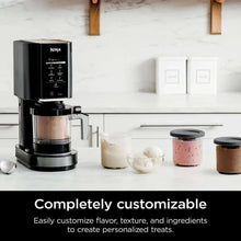 Ninja CREAMi ice cream maker with control unit and multiple pints on countertop